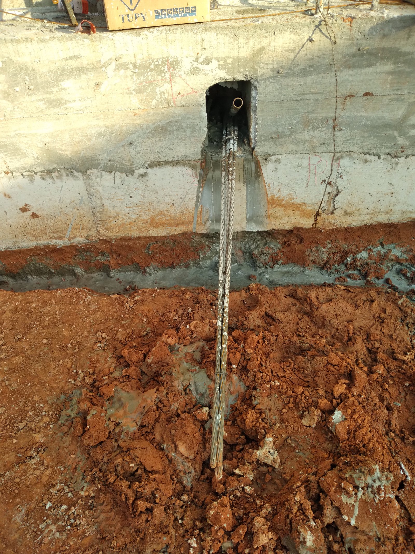 Detalhe de viga baldrame com cabo de aço passando por abertura