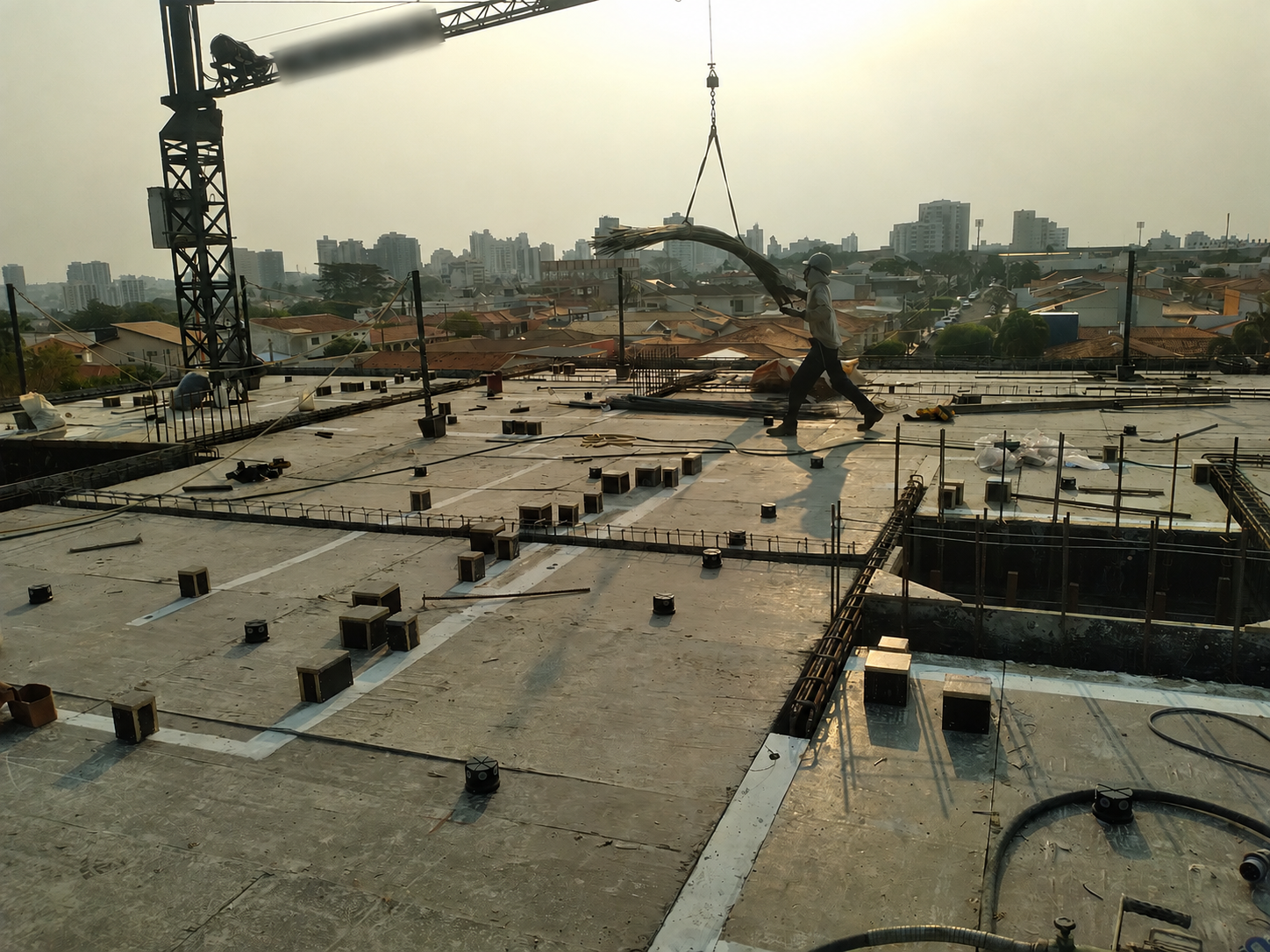 Guindaste içando ferragem no topo da obra com vista da cidade