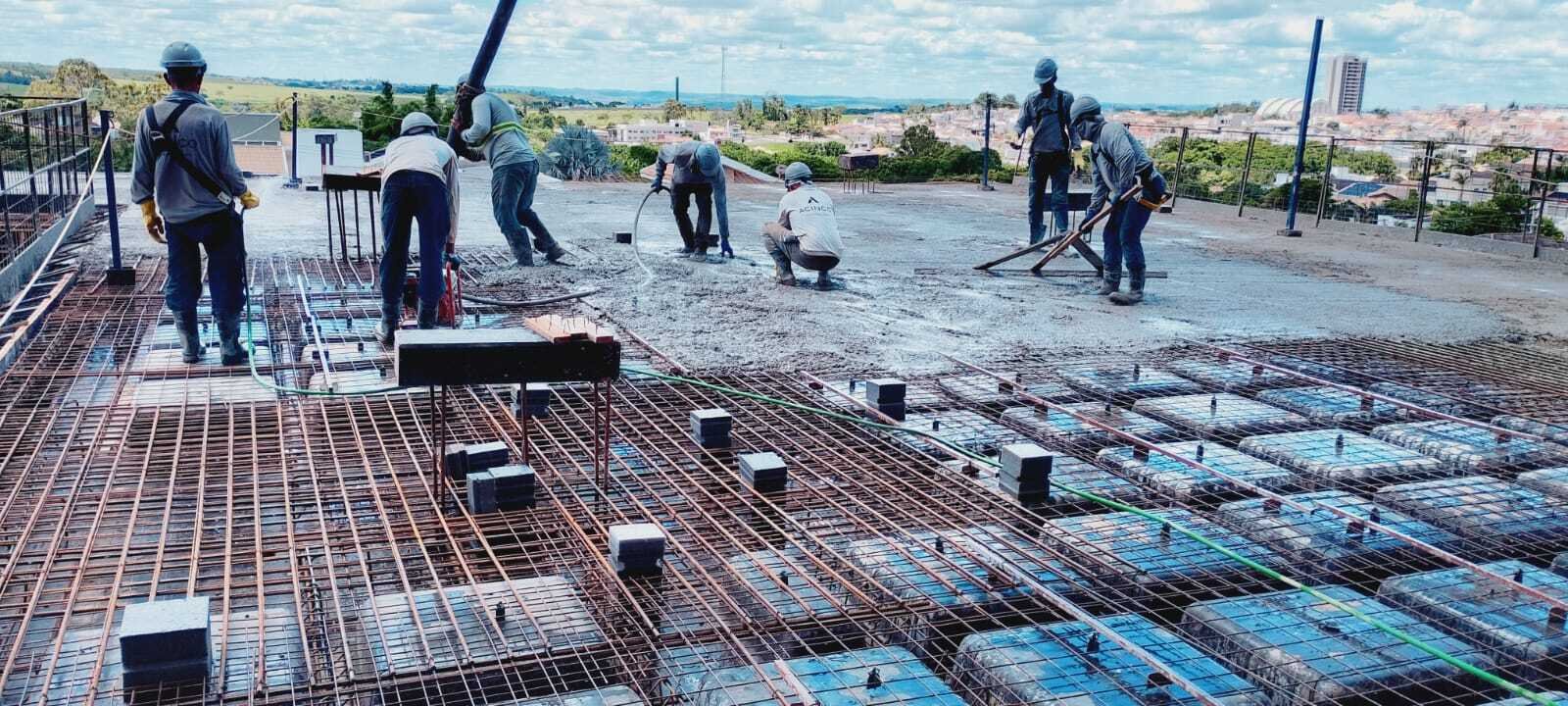 Equipe realizando a concretagem e o acabamento da laje