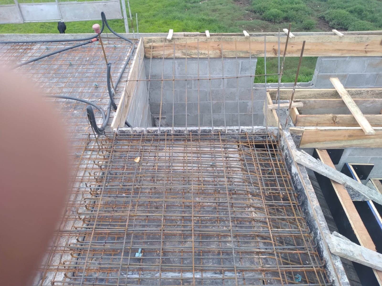 Armação de laje em construção residencial com alvenaria de blocos ao fundo